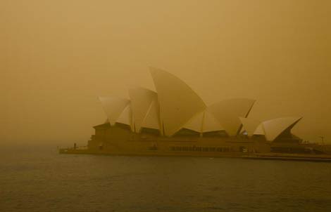 The view of the Sydney Opera House is obscured by red dust from a major dust storm that has engulfed the city.