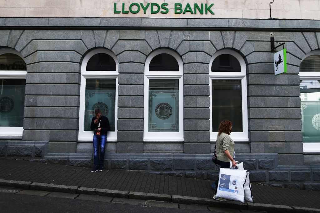 A woman walks past the British bank, Lloyds Bank, on the island of Guernsey