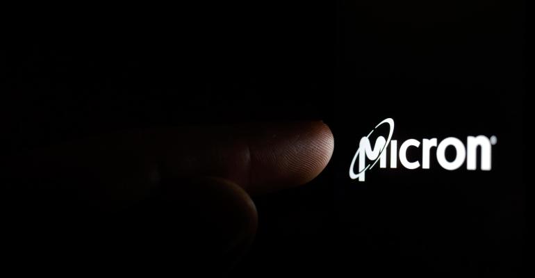 Micron logo on a smartphone screen in a dark and a finger touching it.