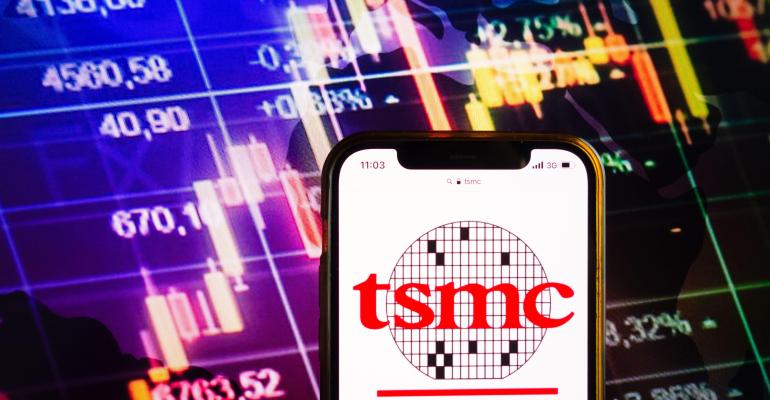 Smartphone displaying logo of Taiwan Semiconductor Manufacturing Company, Limited (TSMC) on stock exchange diagram