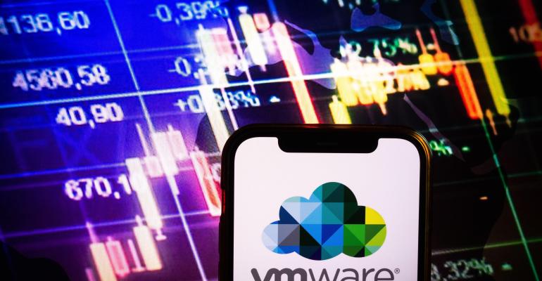 Smartphone displaying logo of VMware company on stock exchange diagram background