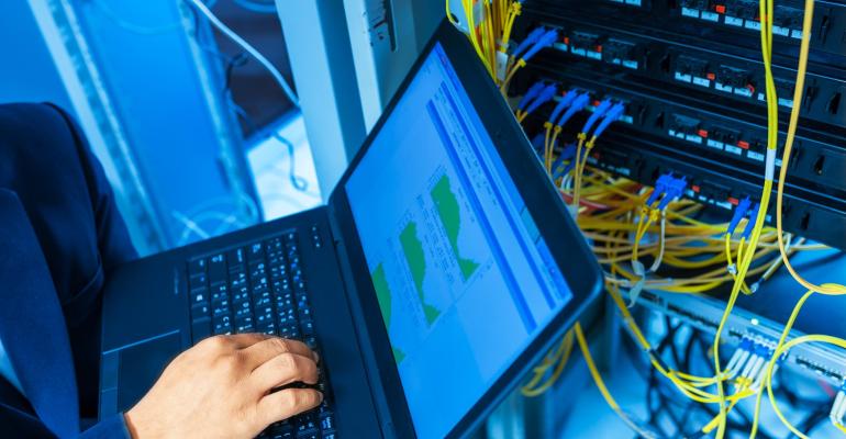 Engineer fixes network switch in data center room