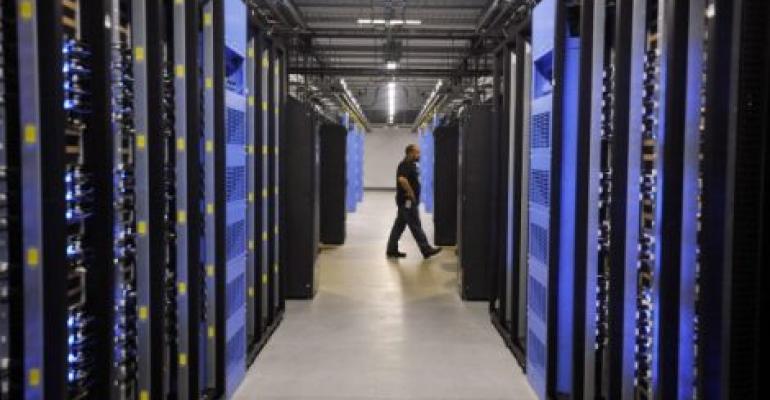 An employee walks past servers in the Facebook data center in Forest City, North Carolina.