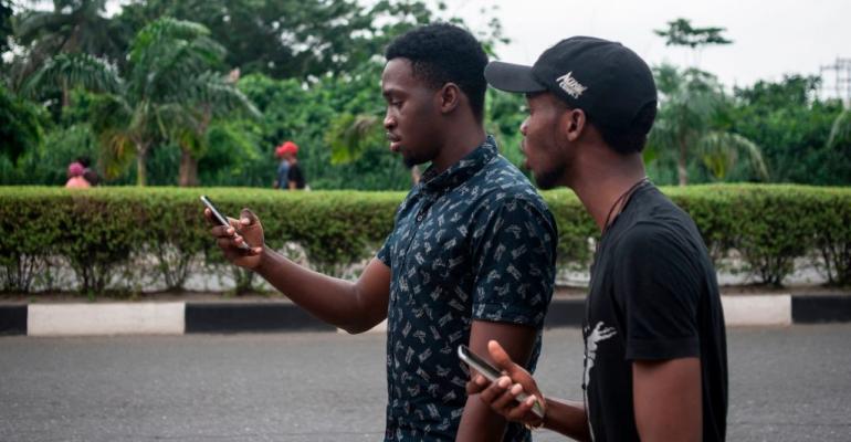 Two young men play the mobile AR game Pokemon Go on the campus grounds of the University of Lagos in Lagos, Nigeria, in 2016.