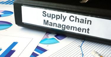 Graphs and file folder with label supply chain management. 