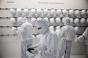 Employees prepare to enter a clean room inside the Infineon Technologies AG semiconductor factory in Villach, Austria.