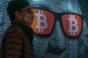 Pedestrians walk past a display of cryptocurrency Bitcoin on February 15, 2022 in Hong Kong, China. 